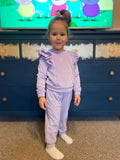 little girl posing in a lillac tracksuit
