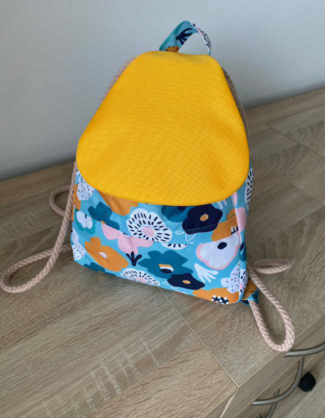 a floral fabric drawstring backpack with removable flap