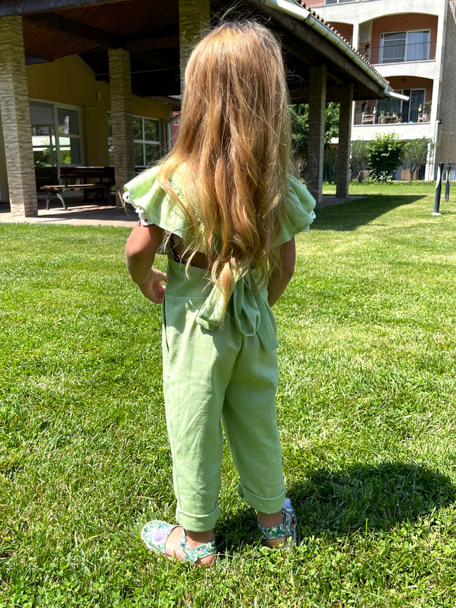 back of a little girl wearing a green jumpsuit