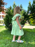 side view of a girl wearing a green dress